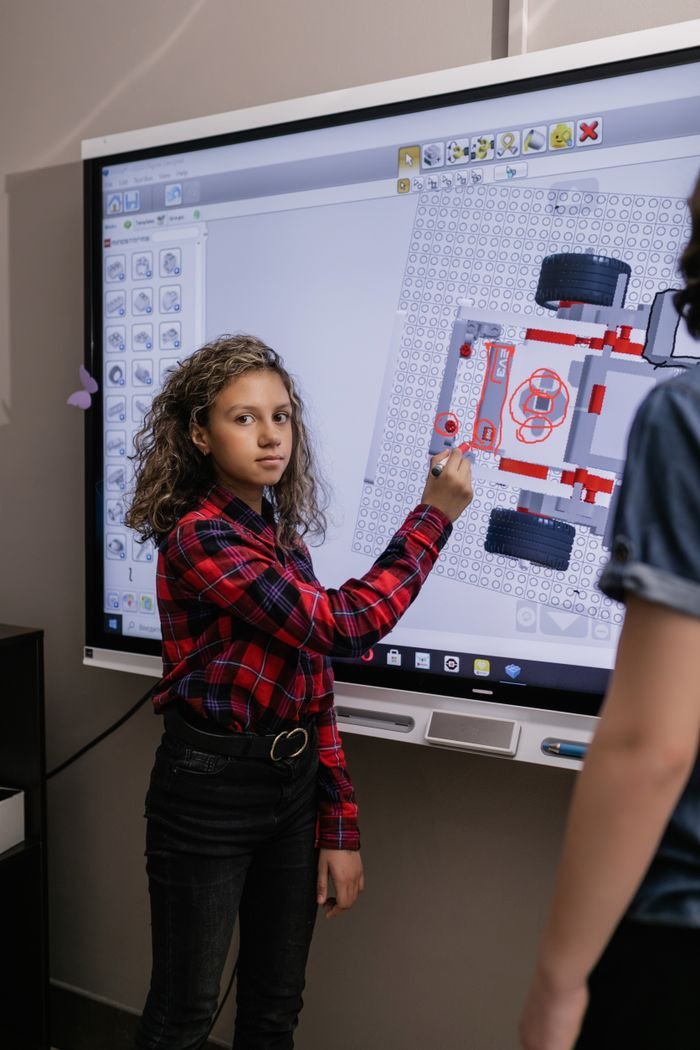 Girl using interactive board in a classroom exploring educational content.